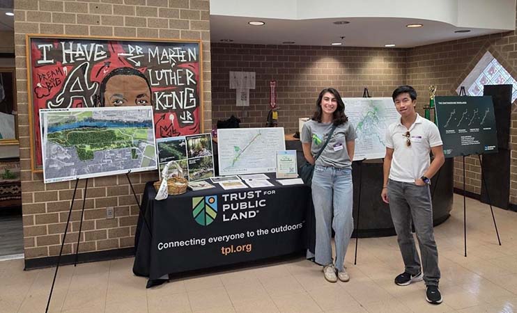 Students in front of display table with information about Trust for Public Land