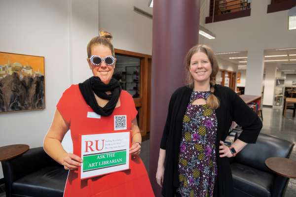 Megan Lotts next to cutout figure of self holding Ask the Art Librarian sign.