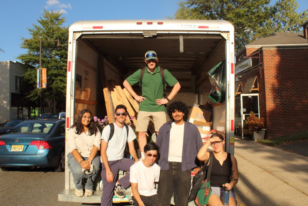 Students in back of rental box van with parking day structures and setup.